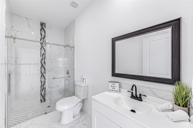 bathroom with vanity, toilet, and a shower with door