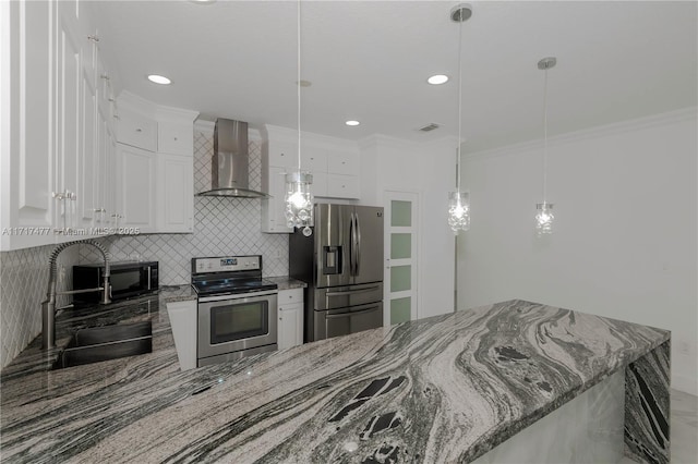 kitchen with white cabinetry, sink, wall chimney range hood, decorative light fixtures, and appliances with stainless steel finishes