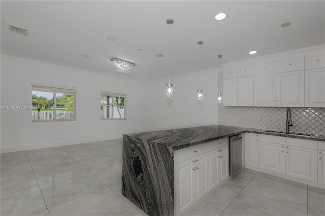 kitchen featuring dark stone counters, white cabinets, sink, ornamental molding, and decorative light fixtures