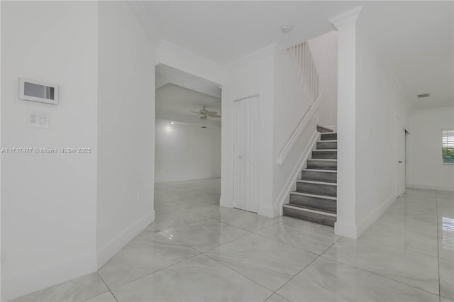 stairway featuring ceiling fan and crown molding