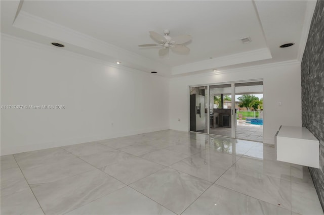 unfurnished room featuring a tray ceiling, ceiling fan, and ornamental molding