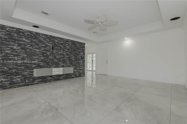 unfurnished room with ceiling fan, a raised ceiling, and ornamental molding