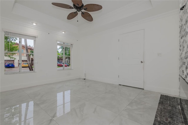 spare room featuring a raised ceiling, ceiling fan, and ornamental molding