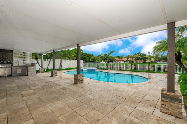 view of swimming pool featuring sink, a patio area, exterior kitchen, and an in ground hot tub