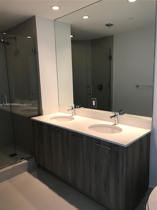 bathroom featuring vanity and a shower with shower door