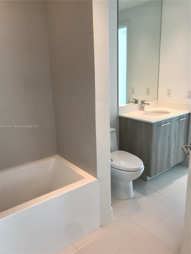 bathroom with tile patterned floors, vanity, toilet, and a washtub