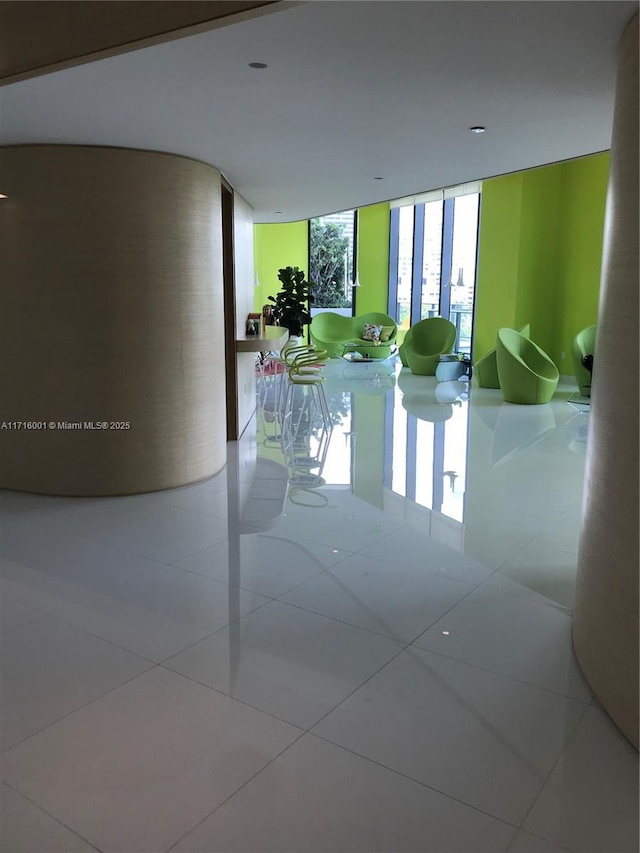 hallway with light tile patterned floors and floor to ceiling windows