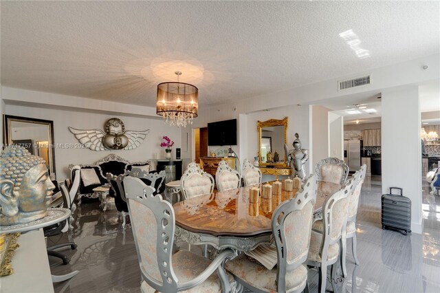 dining area featuring a textured ceiling and a notable chandelier