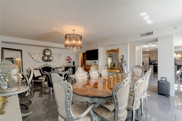 dining space with a notable chandelier and a textured ceiling