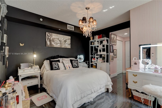 bedroom featuring dark hardwood / wood-style flooring, a chandelier, and a textured ceiling