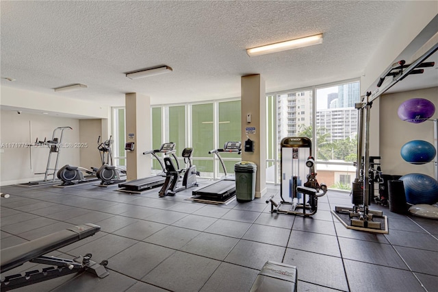 exercise room featuring expansive windows and a textured ceiling