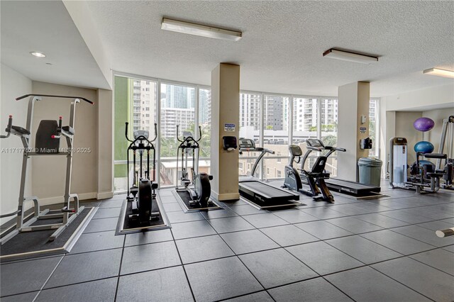 gym featuring floor to ceiling windows and a textured ceiling