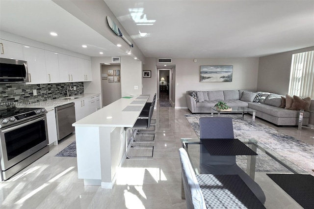 kitchen featuring sink, white cabinetry, appliances with stainless steel finishes, and a kitchen island