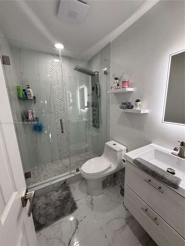 bathroom with vanity, toilet, and a shower with door