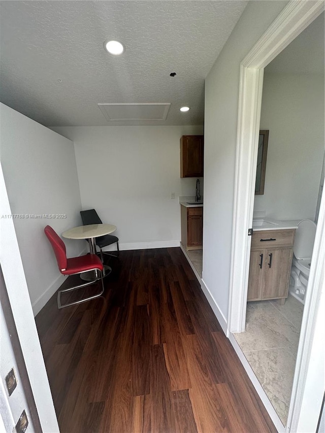 hallway with a textured ceiling and dark wood-type flooring