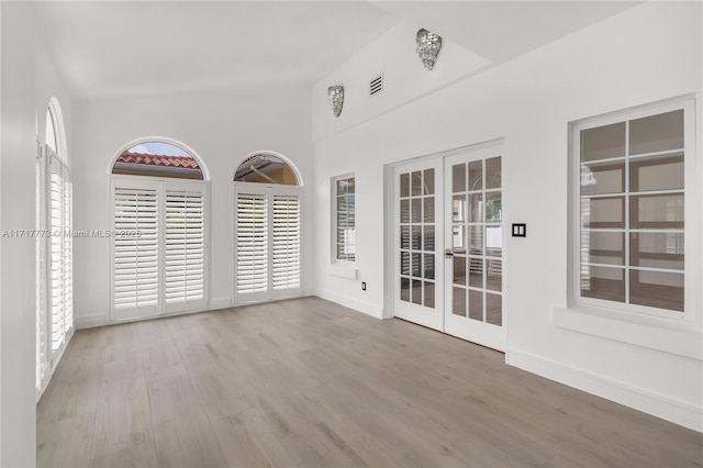 unfurnished room featuring french doors and light wood-type flooring