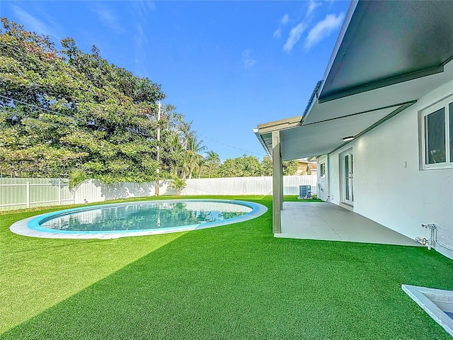 view of swimming pool featuring central air condition unit, a patio area, and a lawn