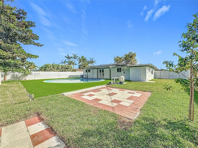 back of house featuring a patio, a fenced in pool, and a lawn