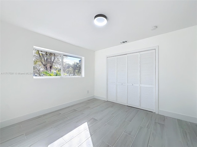 unfurnished bedroom featuring a closet and light hardwood / wood-style floors