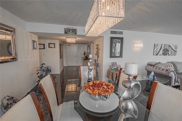 tiled dining area with a textured ceiling