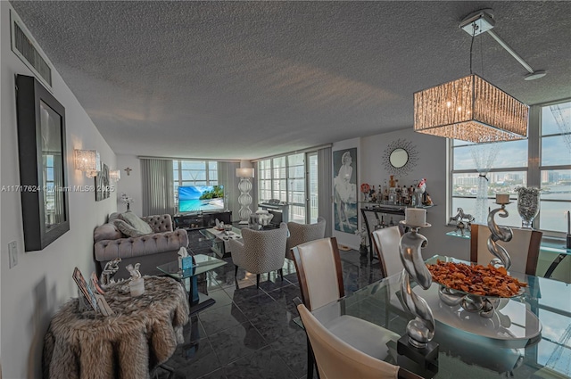 dining space with floor to ceiling windows and a textured ceiling