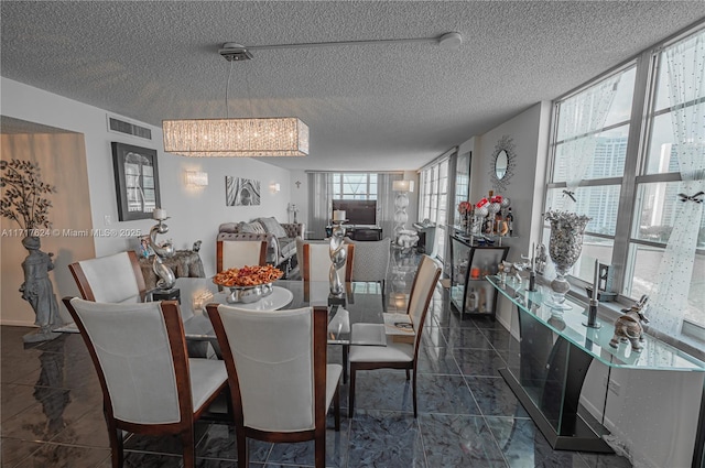 dining area with a chandelier, a textured ceiling, and a wall of windows