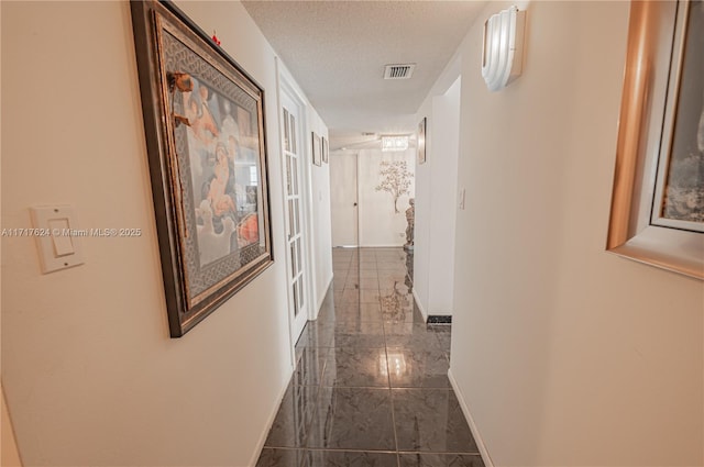 corridor featuring a textured ceiling