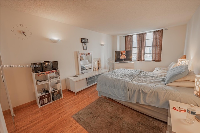 bedroom with a textured ceiling and light hardwood / wood-style flooring