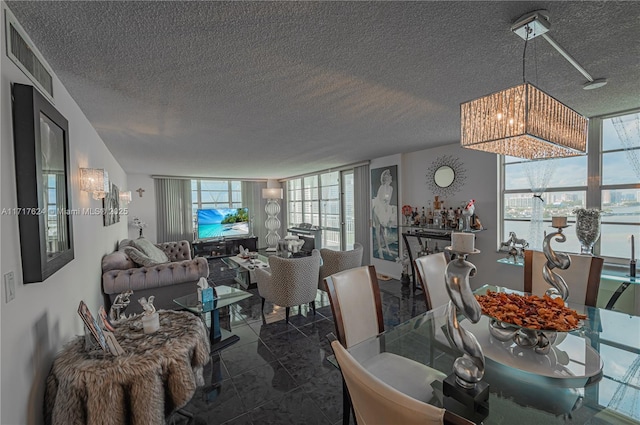 dining area featuring a textured ceiling and a wall of windows