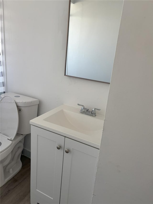 bathroom featuring vanity, toilet, and wood-type flooring