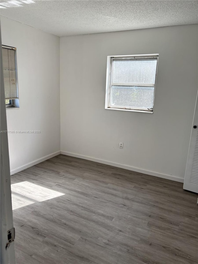 unfurnished room featuring hardwood / wood-style floors and a textured ceiling