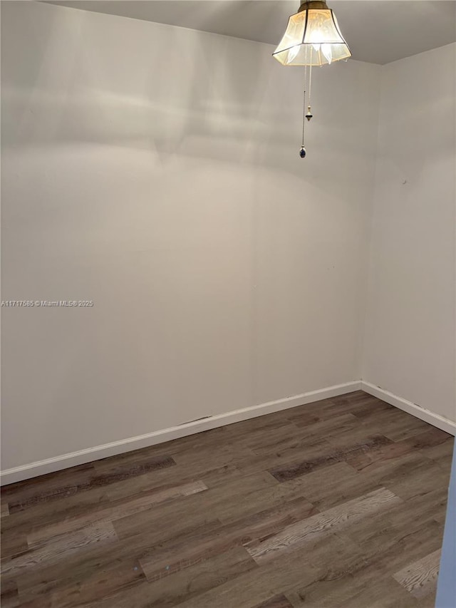 unfurnished room with dark wood-type flooring