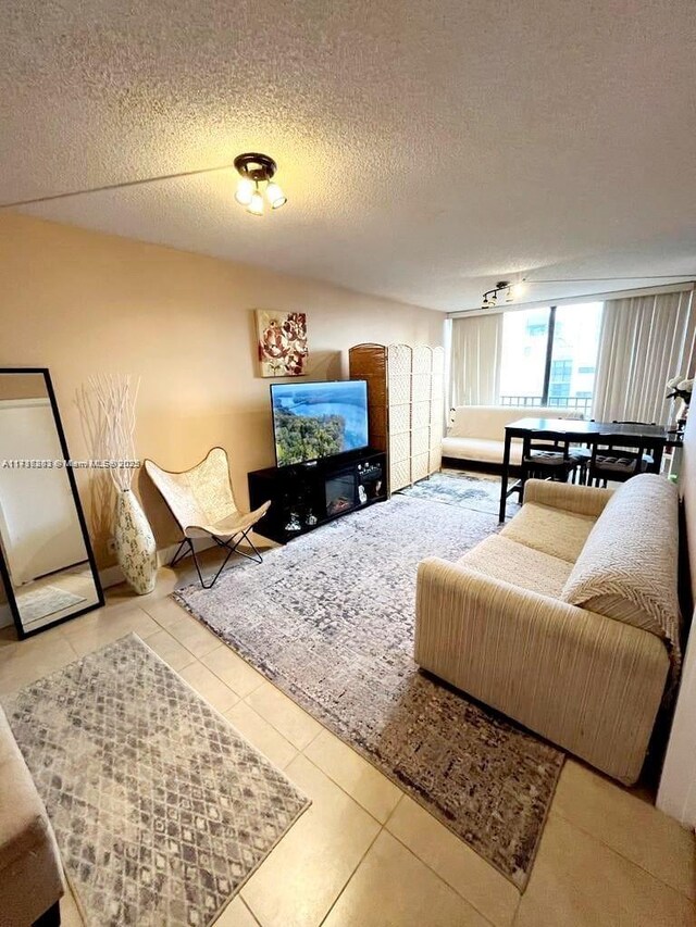 tiled living room featuring a textured ceiling