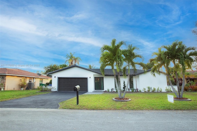 single story home featuring an attached garage, driveway, stucco siding, and a front lawn