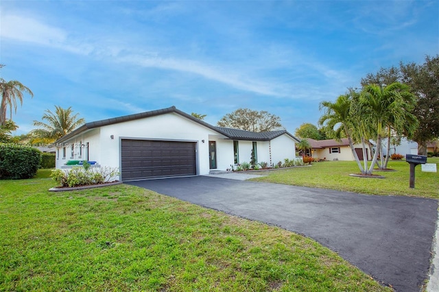ranch-style house featuring a garage, a front yard, driveway, and stucco siding