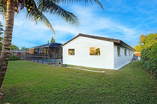 view of property exterior featuring an outdoor pool, a lanai, a lawn, and stucco siding