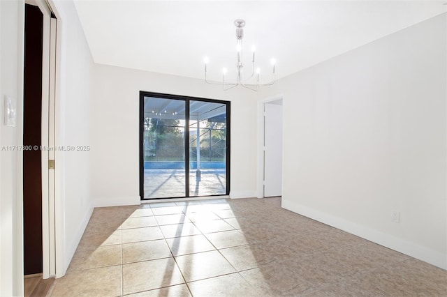 tiled spare room featuring a chandelier