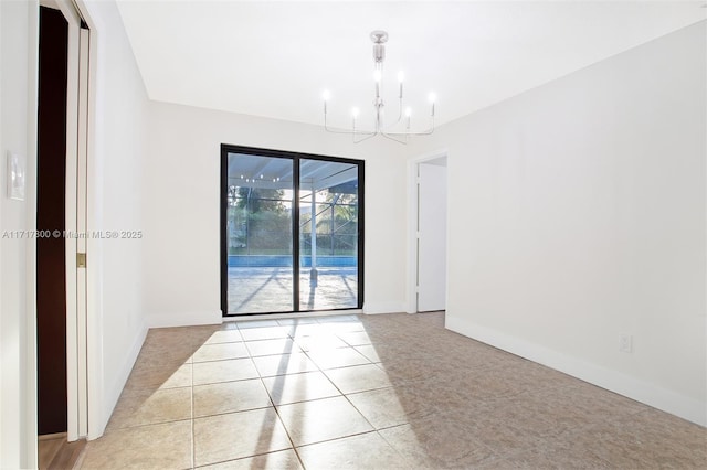 empty room featuring baseboards and an inviting chandelier