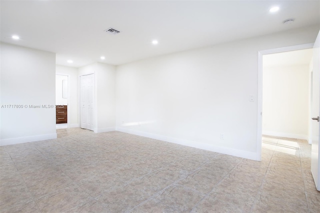 unfurnished room featuring recessed lighting, visible vents, and baseboards