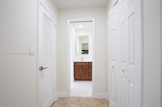 hall with recessed lighting, baseboards, and light tile patterned flooring
