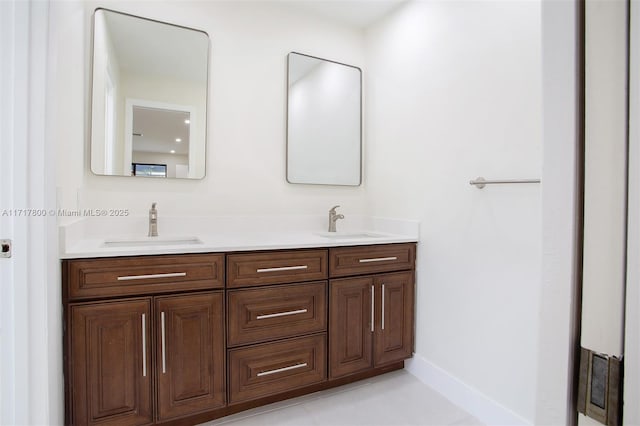 bathroom featuring double vanity, baseboards, and a sink