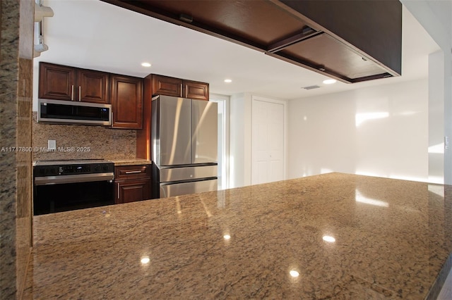 kitchen with dark brown cabinets, light stone countertops, decorative backsplash, and stainless steel appliances
