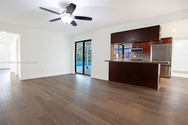 unfurnished living room with dark hardwood / wood-style floors and ceiling fan