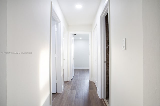 hallway with wood finished floors, baseboards, and recessed lighting