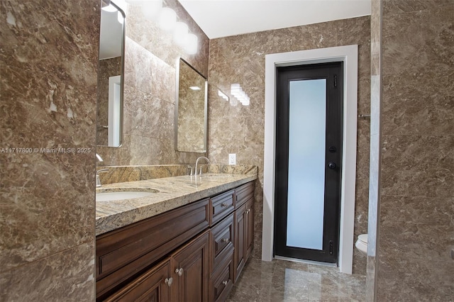 full bath featuring a sink, tile walls, and toilet