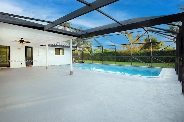 view of pool featuring a yard, a patio, ceiling fan, and glass enclosure