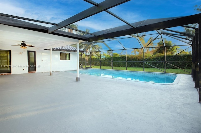 outdoor pool featuring a patio, glass enclosure, and a ceiling fan