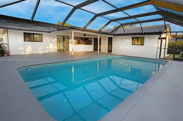 pool featuring a patio area, ceiling fan, and glass enclosure