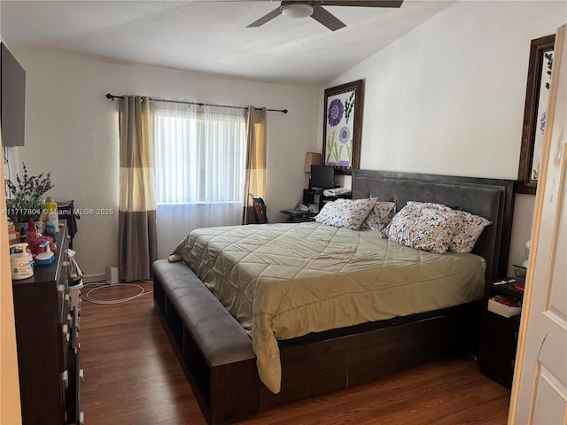 bedroom featuring ceiling fan, dark wood-type flooring, and lofted ceiling