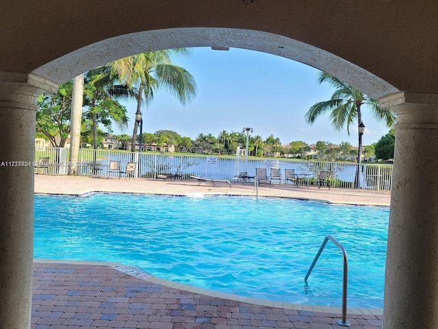 view of swimming pool with a patio and a water view